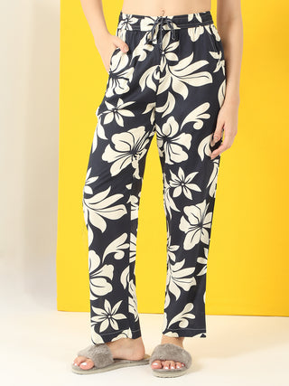 Women in a relaxed pose wearing navy blue floral printed sleepwear pants.