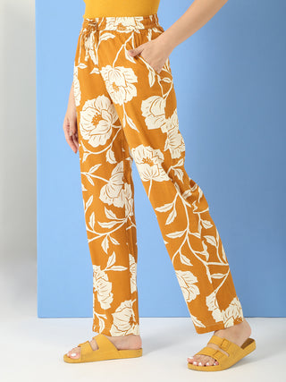 Women in a side-view pose wearing mustard yellow floral printed wide-leg sleep pants.