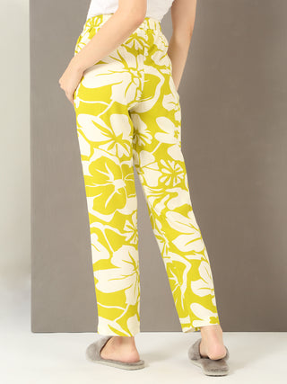 Women in a back-view pose wear light yellow floral print pajama pants.