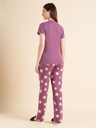 Woman wearing a purple t-shirt with white stars on purple pants.