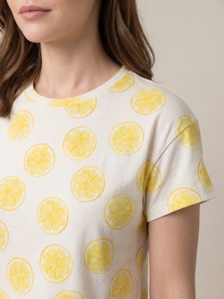 A woman wearing a white t-shirt with a lemon print.