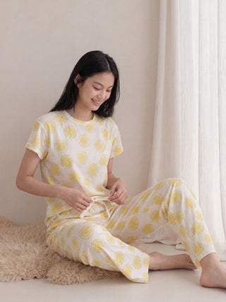 Women's light yellow pajama set with a lemon print, back view.