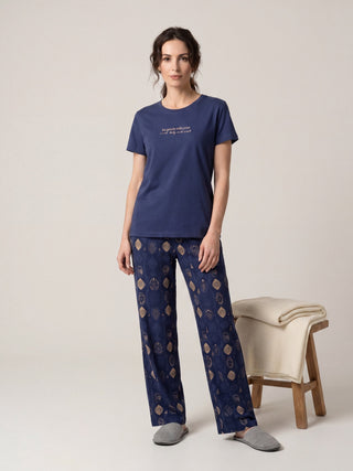 Women in navy blue printed pajama set, full body shot.