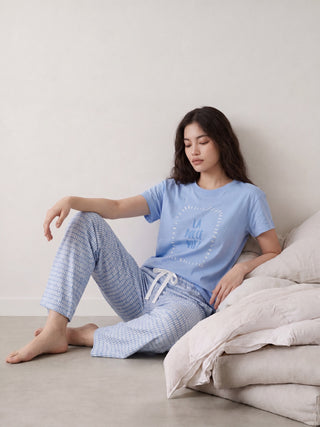 Women in light blue printed pajamas and white slippers, standing from the back.