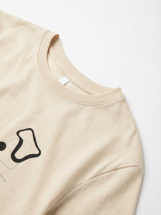 Women's light beige t-shirt with abstract black graphic print and text detail.
