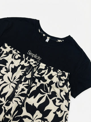 Women's black t-shirt with "Simplicity" printed in white and matching black and white floral print pajama shorts.