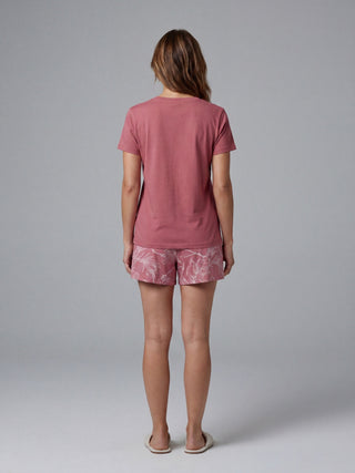 Women's dusty rose short-sleeve t-shirt and floral-print shorts, viewed from the back.
