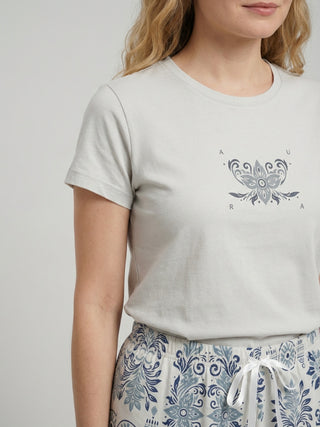 Women's light gray t-shirt with a floral logo and patterned pajama pants.