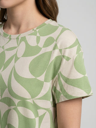 Women wearing a short-sleeved t-shirt with a light green and beige abstract geometric print.