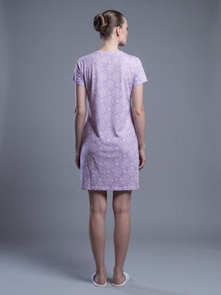 Women in a standing pose wearing a lilac short-sleeve sleep dress with a leaf print.