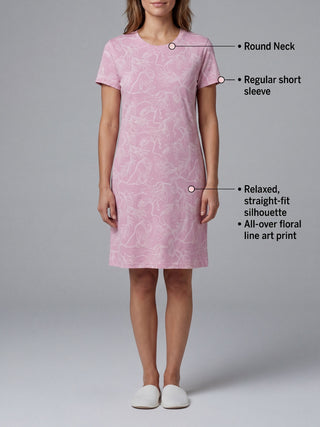 Women in a relaxed, straight-fit pink t-shirt dress with an all-over floral line art print, wearing white slippers.