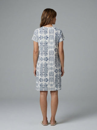Women wearing a white short-sleeved knee-length dress with a blue damask print.
