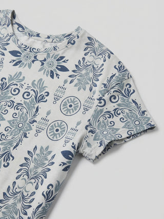 Women's light grey short-sleeved t-shirt with a blue ornate floral and candle print, laying flat.