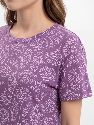 Women's purple t-shirt with an all-over white script print.