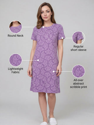 Women in a relaxed pose wearing a purple, all-over abstract scribble print, short-sleeve nightgown.