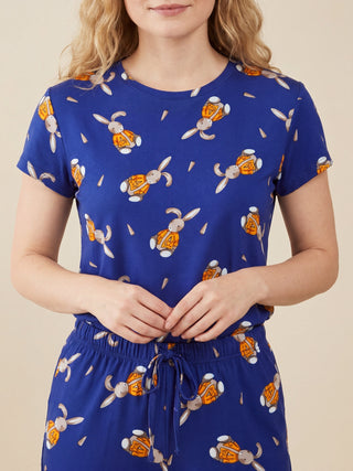 Woman in blue pajamas with a bunny and carrot print.