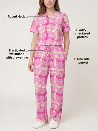 Women in a pink wavy checkered pajama set, standing and facing forward with the top partially buttoned.