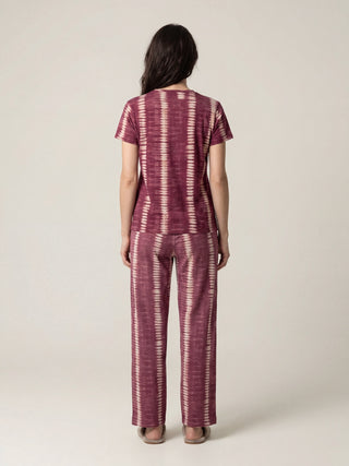 Woman, back view, wearing maroon and cream tie-dye t-shirt and matching pants.