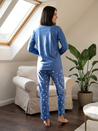 Women in blue long-sleeve pajamas with white stars, standing with their back to the camera.