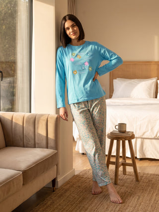 Woman in a light blue long-sleeve pajama set with a floral print.