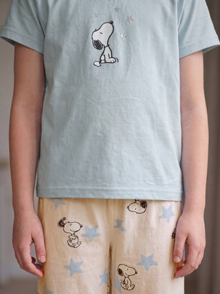 GIRLS short-sleeved light blue t-shirt with a Snoopy print and matching light peach shorts with Snoopy and star print.