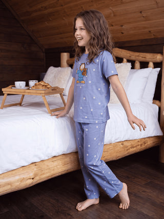 Girls in a playful pose wear blue polka dot Garfield pajamas.