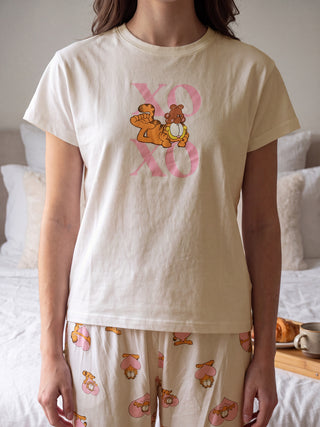 Woman in beige pajamas with Garfield print.