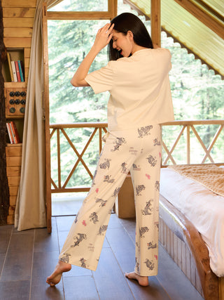 Women in a light-colored, printed pajama set standing with one foot forward.