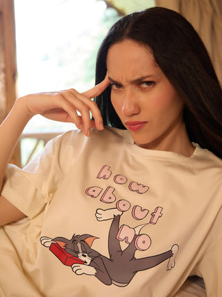 A woman wearing a cream-colored t-shirt with a "How about no?" Tom and Jerry print, with her hand on her forehead and a stern expression.
