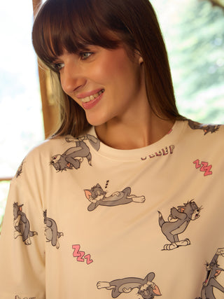 Women wearing a cream-colored sleep shirt with a "Tom and Jerry" all-over print, smiling and looking to the side.