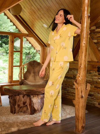 A woman in yellow pajama set with duck print.