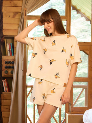 Women wearing a cream-colored pajama set with a Daffy Duck print.