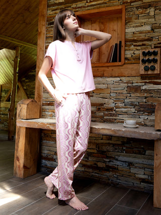 A woman in pink pajama set with paisley print.