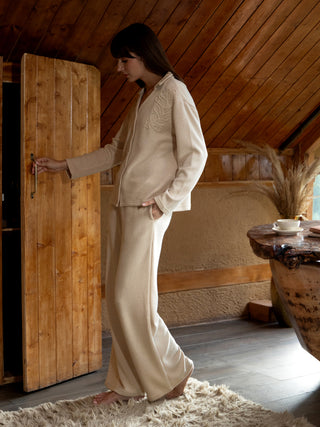A woman in a beige loungewear set with a leaf print.
