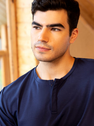 Men in a dark blue cotton Henley shirt.