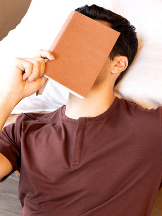 Men's maroon henley loungewear set, shown here with a book covering the face for a relaxed pose.