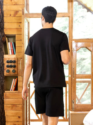 Men in a black sleepwear set, standing with their back to the camera.