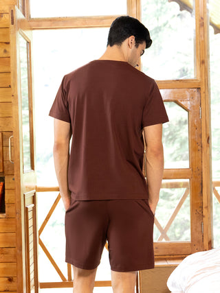 Men in a sleepwear set, dark brown t-shirt and shorts, facing away from the camera.