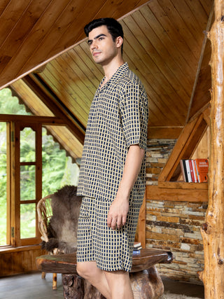 Men's navy and yellow checkered sleepwear set, standing profile view.