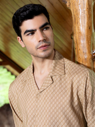 Men in a light brown printed button-up sleep shirt with a camp collar.
