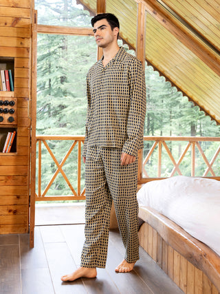 Men wearing a navy and gold geometric print pajama set, standing with feet apart while looking away from the camera.