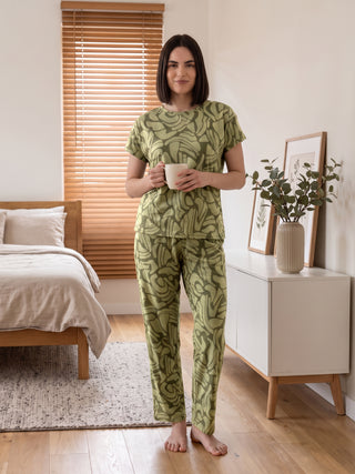 Woman wearing olive green abstract print short sleeve pajama set.