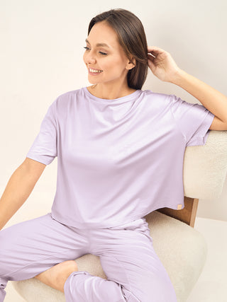 a women sitting giving iconic pose wearing pista colour simply lazy pyjama set made of rip aop