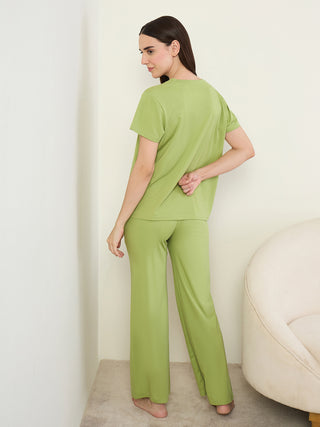 Women in a relaxed pose wearing a lime green two-piece sleepwear set.