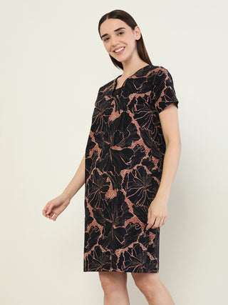 Women posing in a dark navy dress with a large floral print.