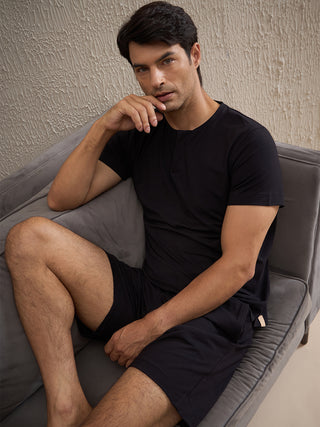 a men sitting wearing black gentlemen solid shorts set made of cotton modal spandex