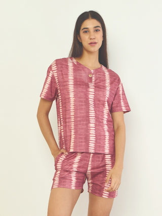 Women in a pink tie-dye sleepwear set with vertical stripes, posing in a relaxed stance.