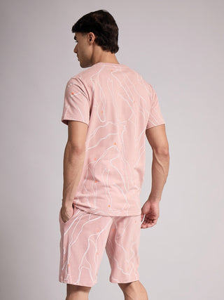 Men in a pink, printed sleepwear set, standing and facing away from the camera.