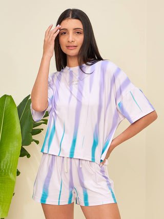 A woman poses wearing a purple and blue tie-dye loungewear set.