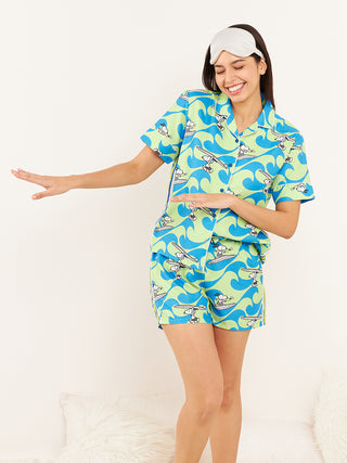 a woman standing against the wall green front open half sleeve bermuda set